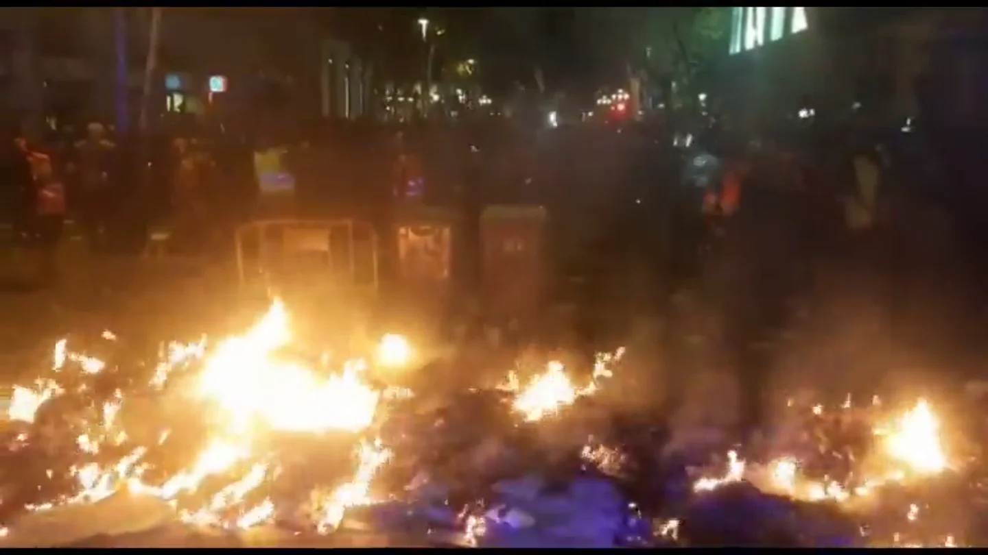 Manifestantes alientan con cartones el fuego de una barricada frente a la Delegación del Gobierno de Barcelona Manifestantes alientan con cartones el fuego de una barricada frente a la Delegación del Gobierno de Barcelona