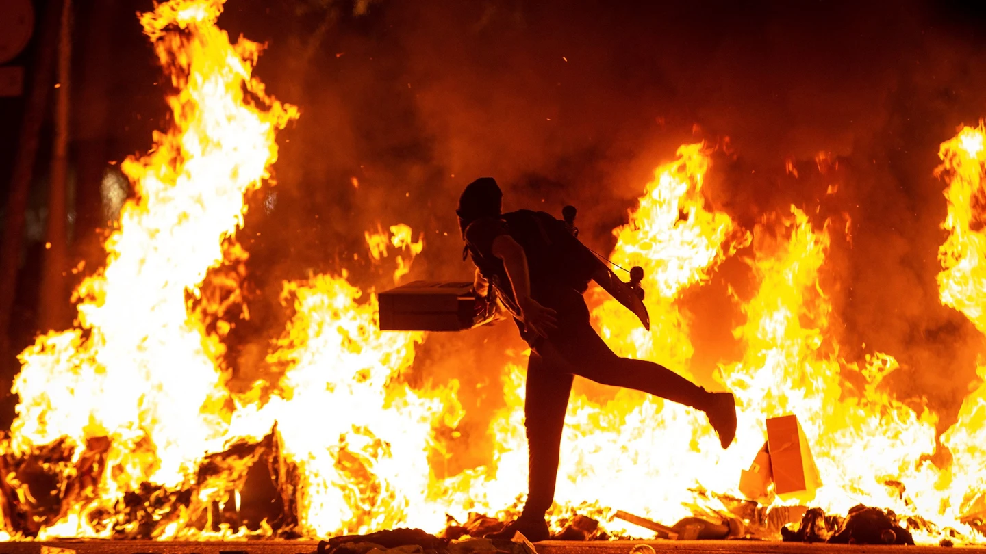 Un manifestante echa al fuego un cartón junto a la Delegación del Gobierno en Barcelona Un manifestante echa al fuego un cartón junto a la Delegación del Gobierno en Barcelona