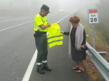 Guardia Civil entregando un chaleco reflectante Guardia Civil entregando un chaleco reflectante