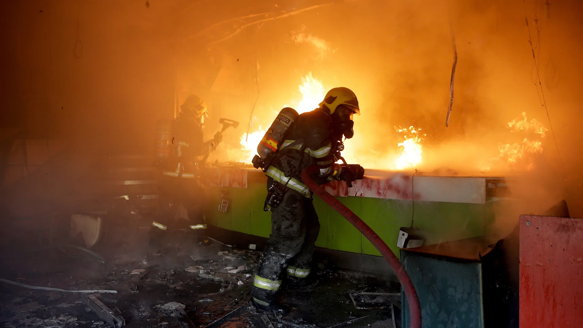 Un bombero trabaja en la extinción de un incendio que se produjo durante una protesta en Chile
