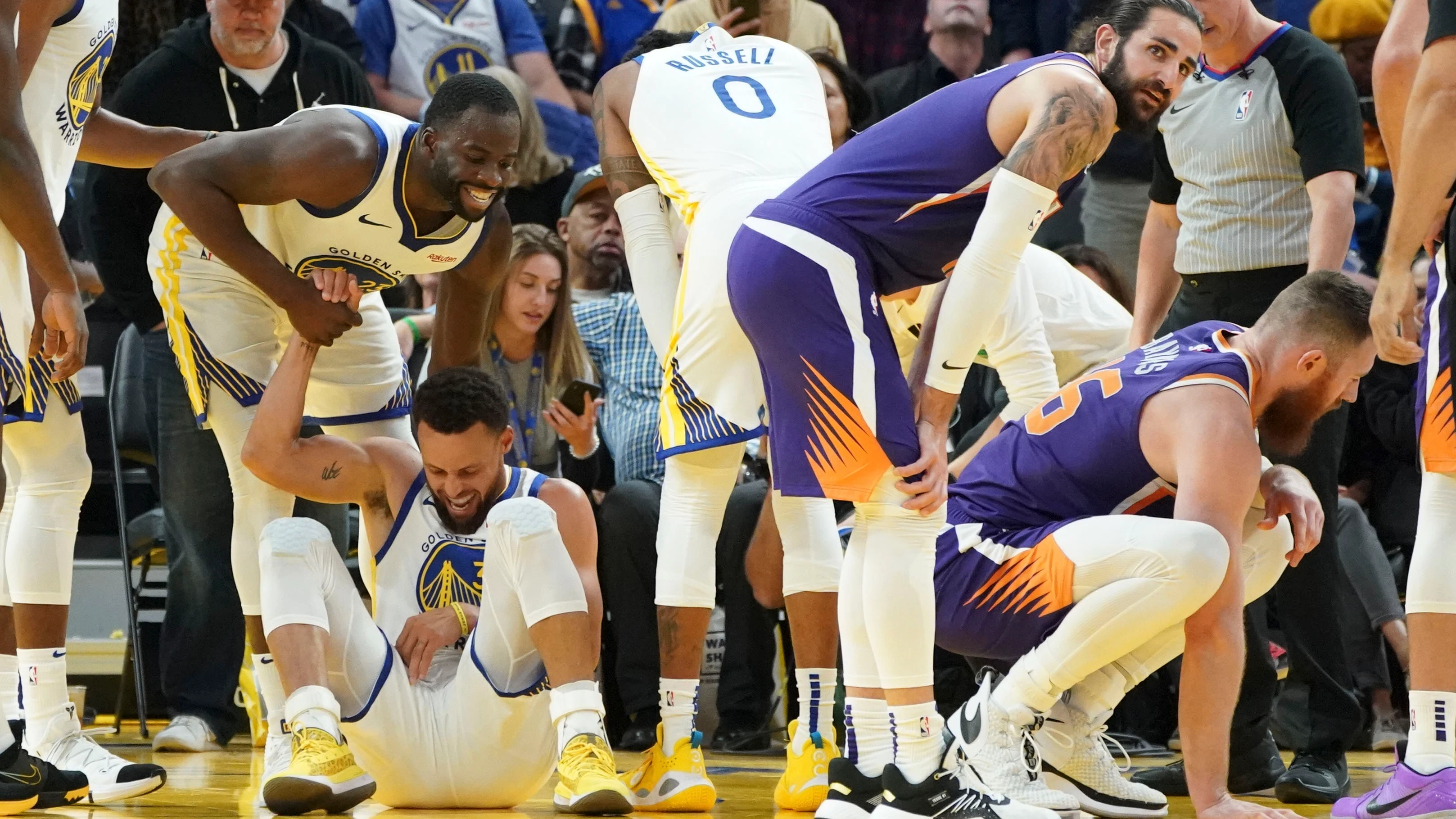 Stephen Curry cae al suelo tras sufrir una grave lesión en su mano izquierda