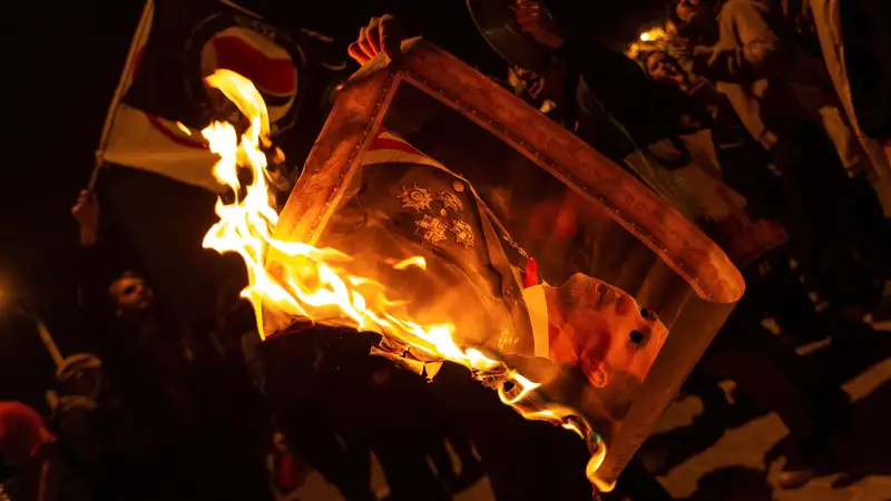 Varios manifestantes queman fotos del rey Felipe durante la protesta llevada a cabo en la avenida Diagonal de Barcelona, en protesta por la visita del rey a la capital catalana