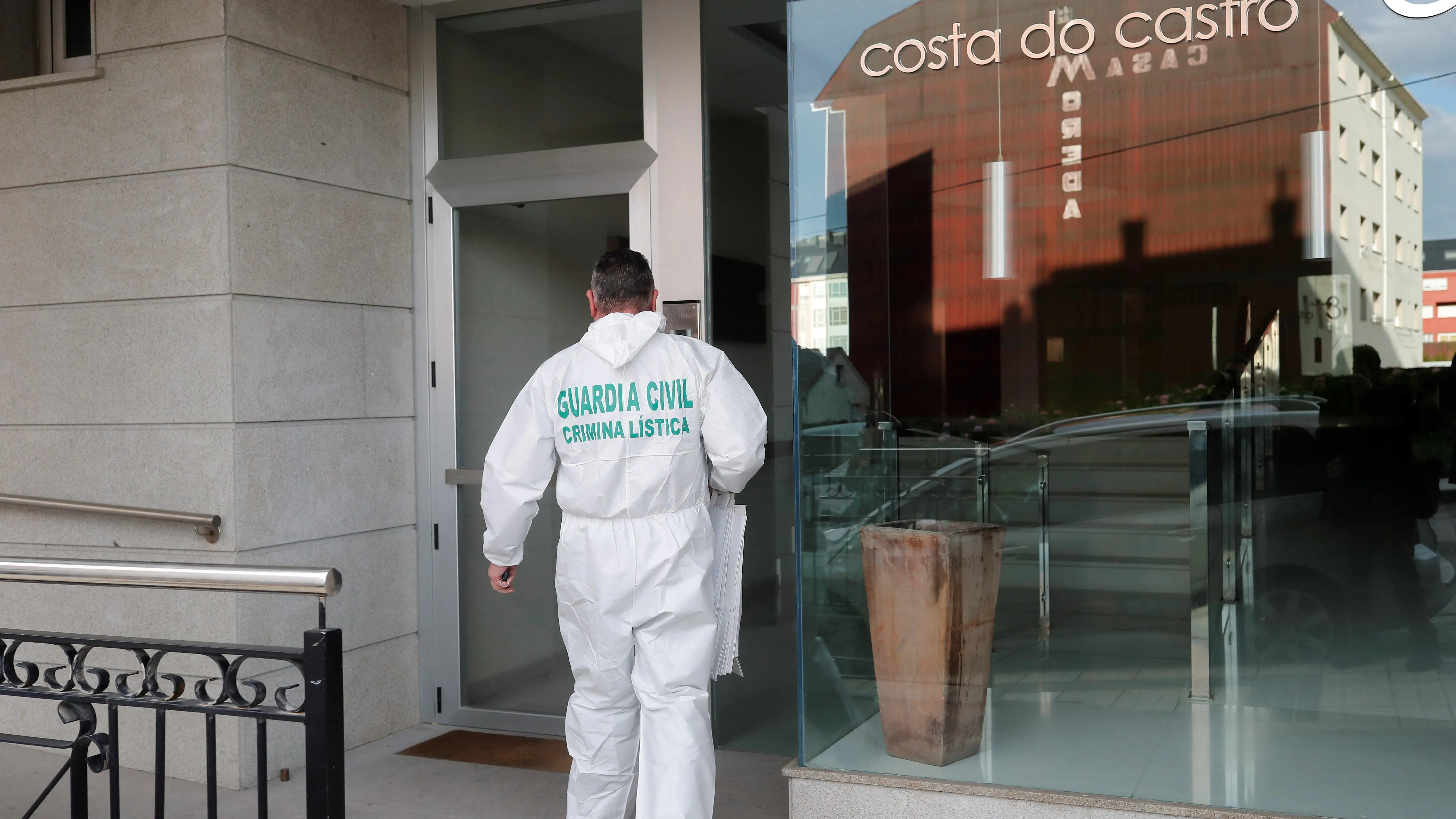 Un agente de la Guardia Civil accede al inmueble en el que fue localizado el cadáver de la mujer presuntamente asesinada por su hijo