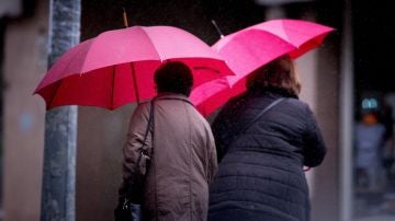 Dos mujeres ser protegen de la lluvia.