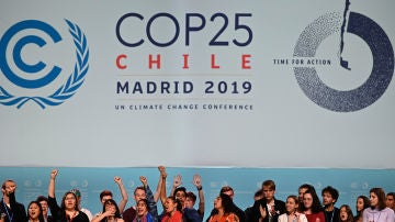 Varios activistas cantan y alzan sus puños después de la sesión plenaria de la Cumbre Climática