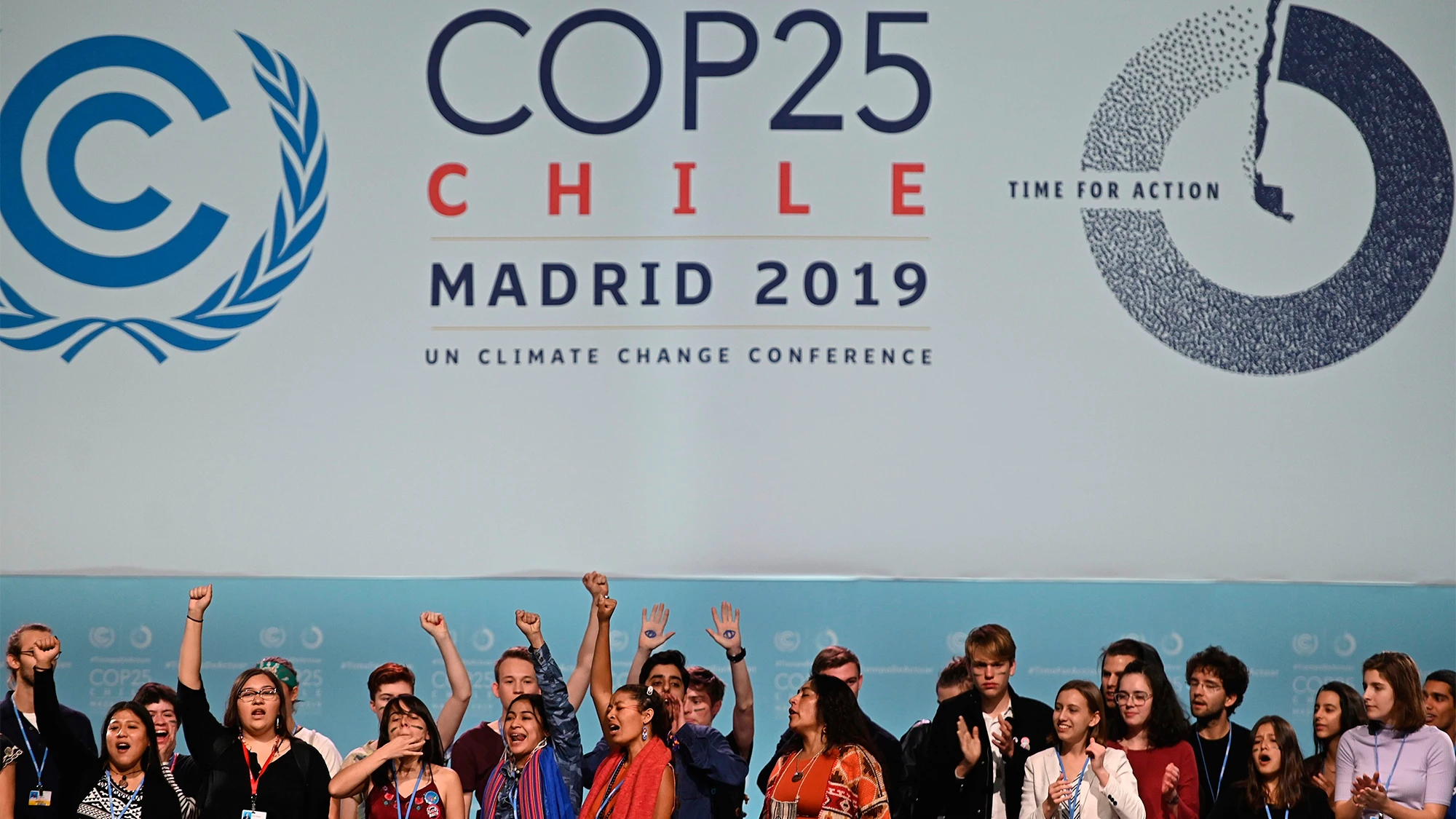 Varios activistas cantan y alzan sus puños después de la sesión plenaria de la Cumbre Climática