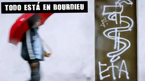Una persona pasa por delante de una pintada en Guernica Todo está en Bourdieu
