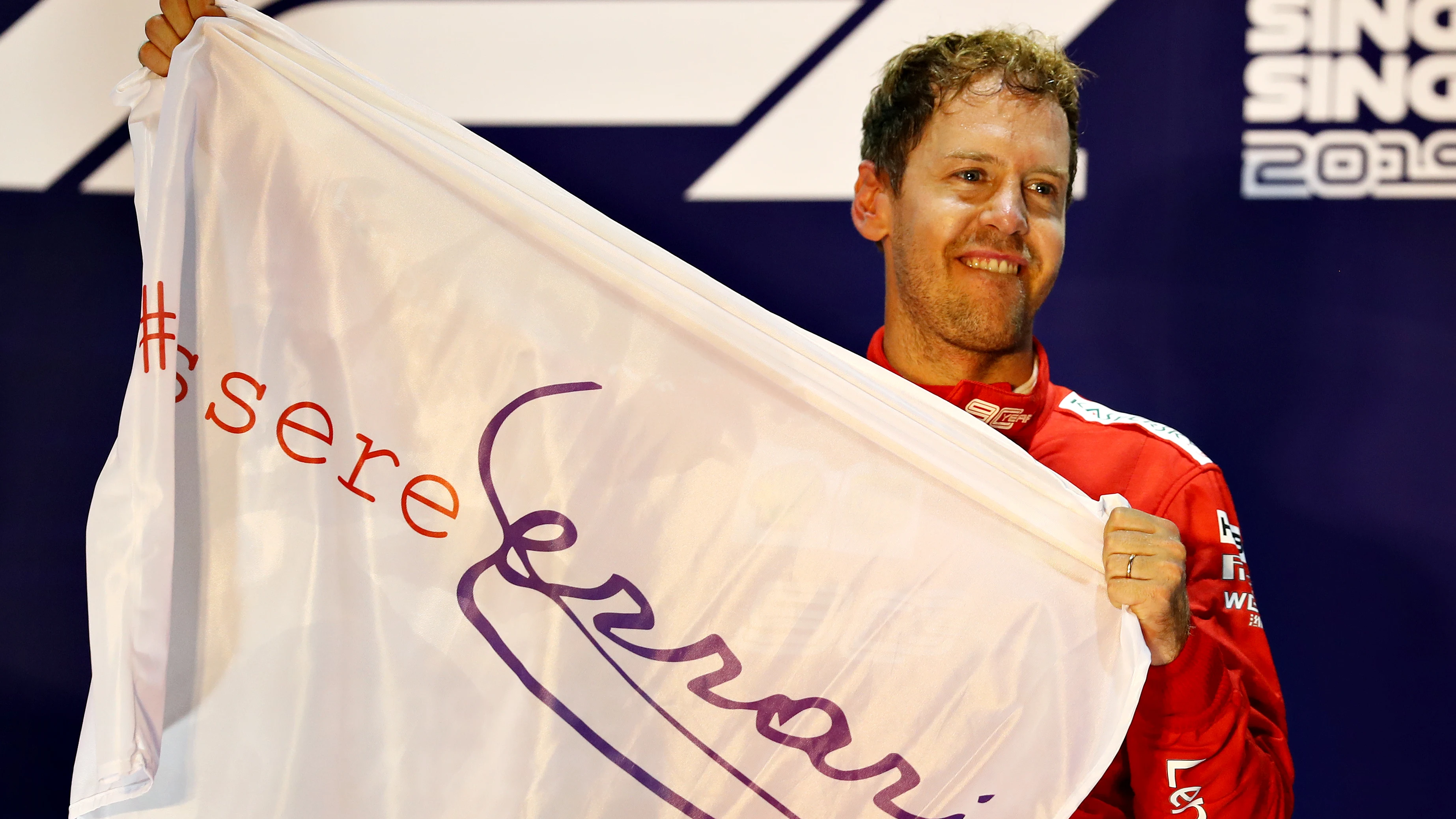 Vettel sostiene una bandera con el lema 'Essere Ferrari' ('Ser Ferrari')