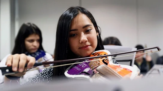 Niña integrante de Cateura mostrando su violín Niña integrante de Cateura mostrando su violín