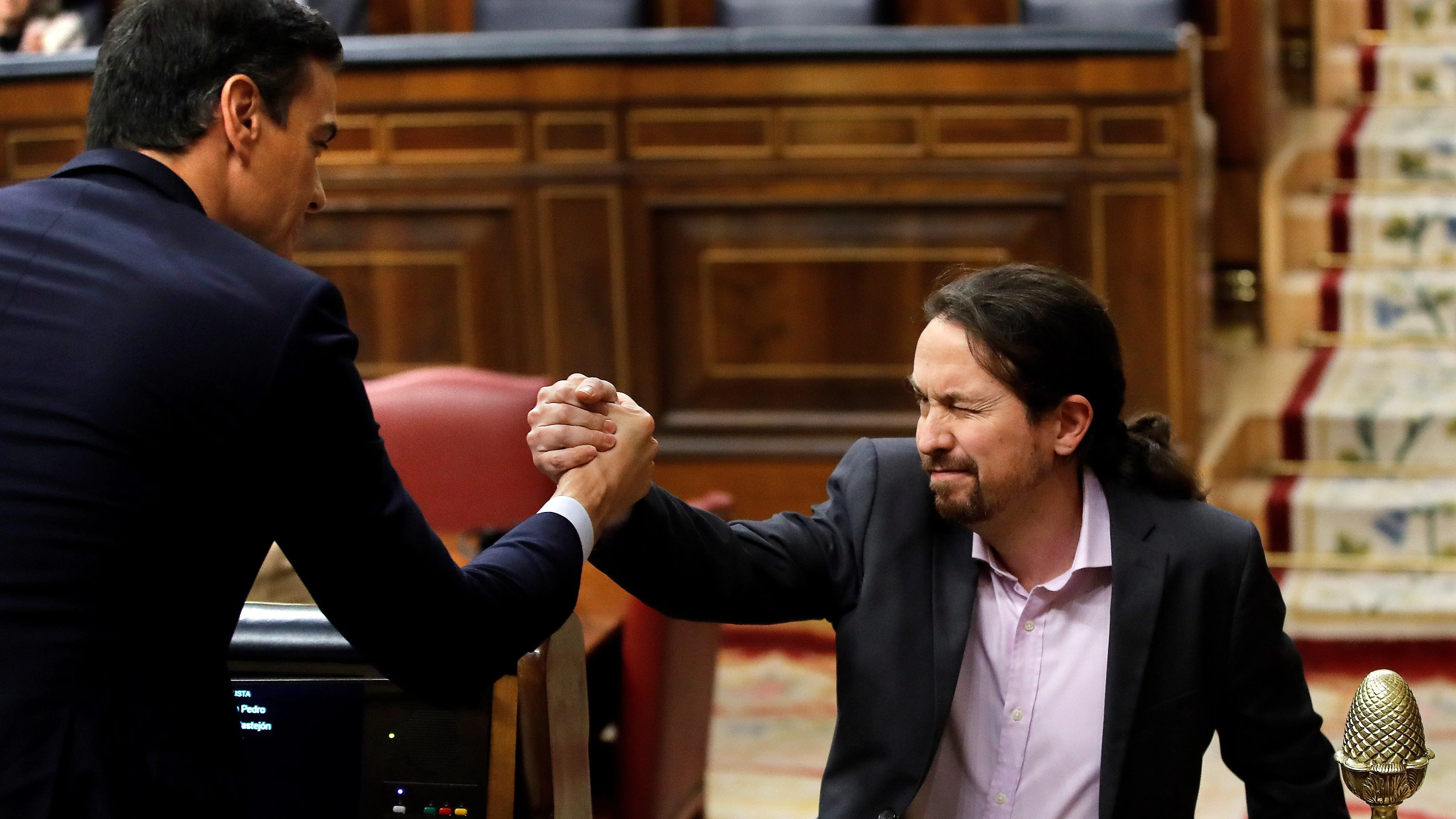 El líder de Unidas Podemos, Pablo Iglesias, saluda a Pedro Sánchez