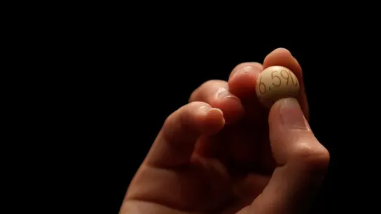 Extraen una bola en un sorteo de Lotería Extraen una bola en un sorteo de Lotería