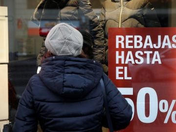 Una consumidora observa el escaparate de una tienda Una consumidora observa el escaparate de una tienda