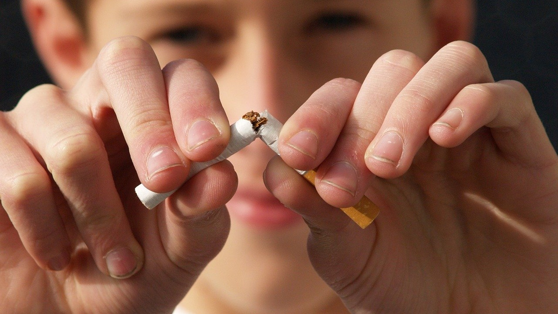 hombre joven rompiendo un cigarrillo