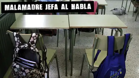 Pupitres vacíos en un aula escolar Malamadre jefa al habla