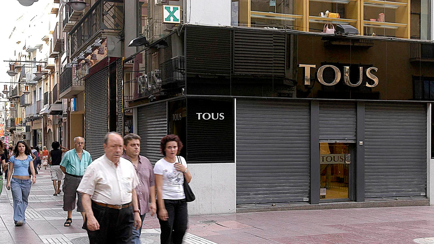 Unos viandantes pasan por delante de una joyería Tous en Lérida Unos viandantes pasan por delante de una joyería Tous en Lérida