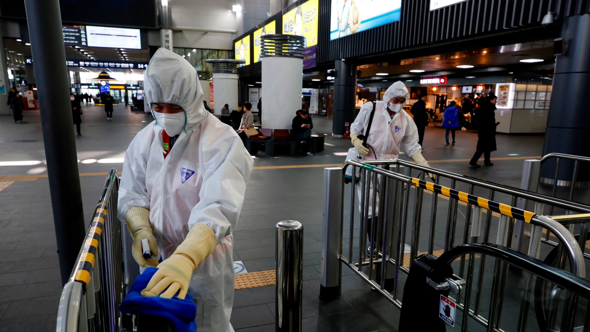 Los trabajadores rocían desinfectante en la estación Suseo en Seúl