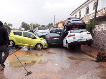 Un hombre limpia la zona y observa los coches amontonados en Málaga Un hombre limpia la zona y observa los coches amontonados en Málaga