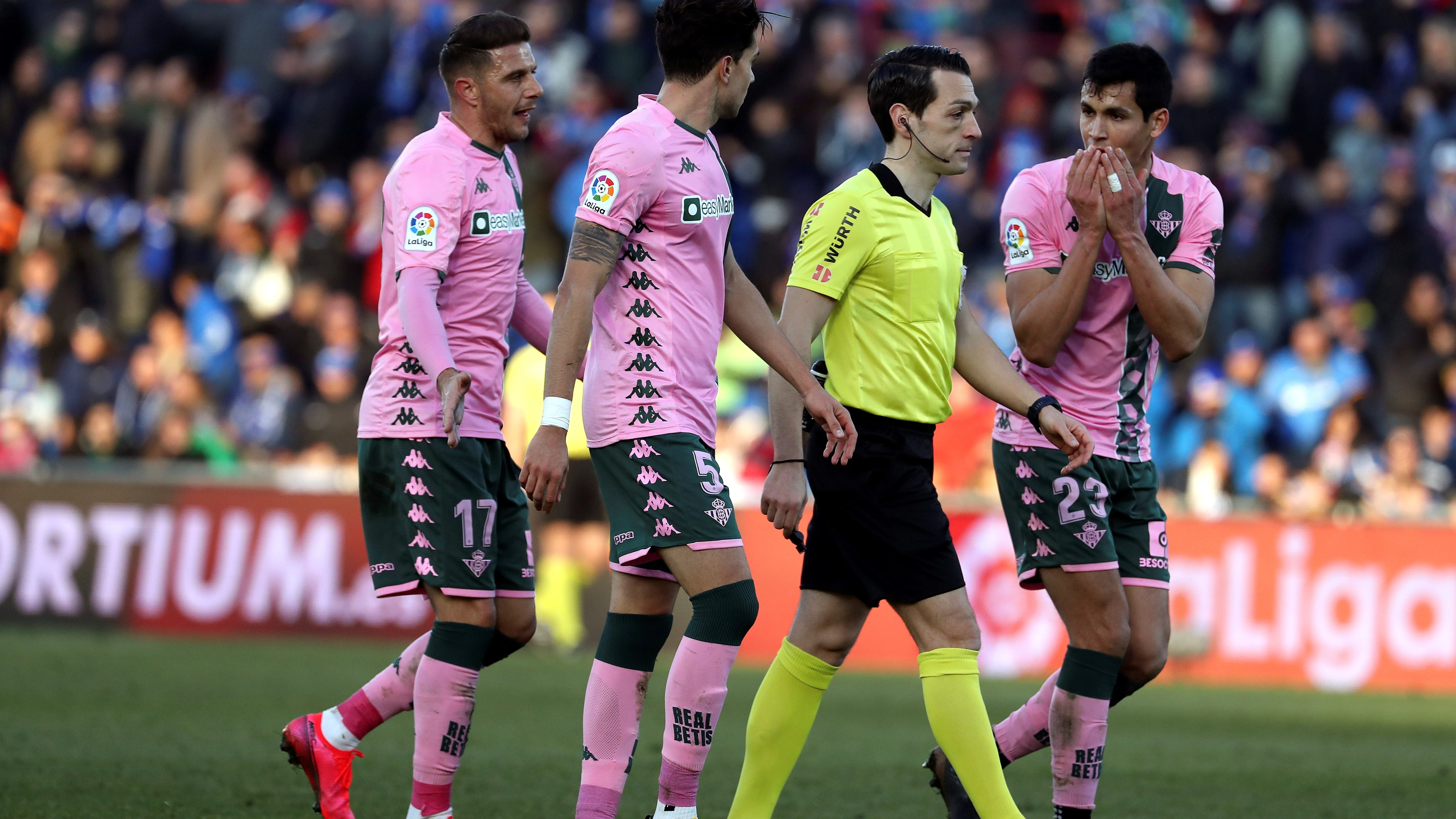 Los jugadores del Betis protestan al árbitro.