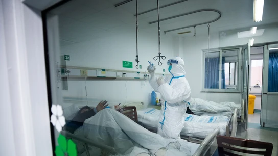 Un sanitario atendiendo a un paciente de coronavirus Un sanitario atendiendo a un paciente en un hospital de Wuhan, China