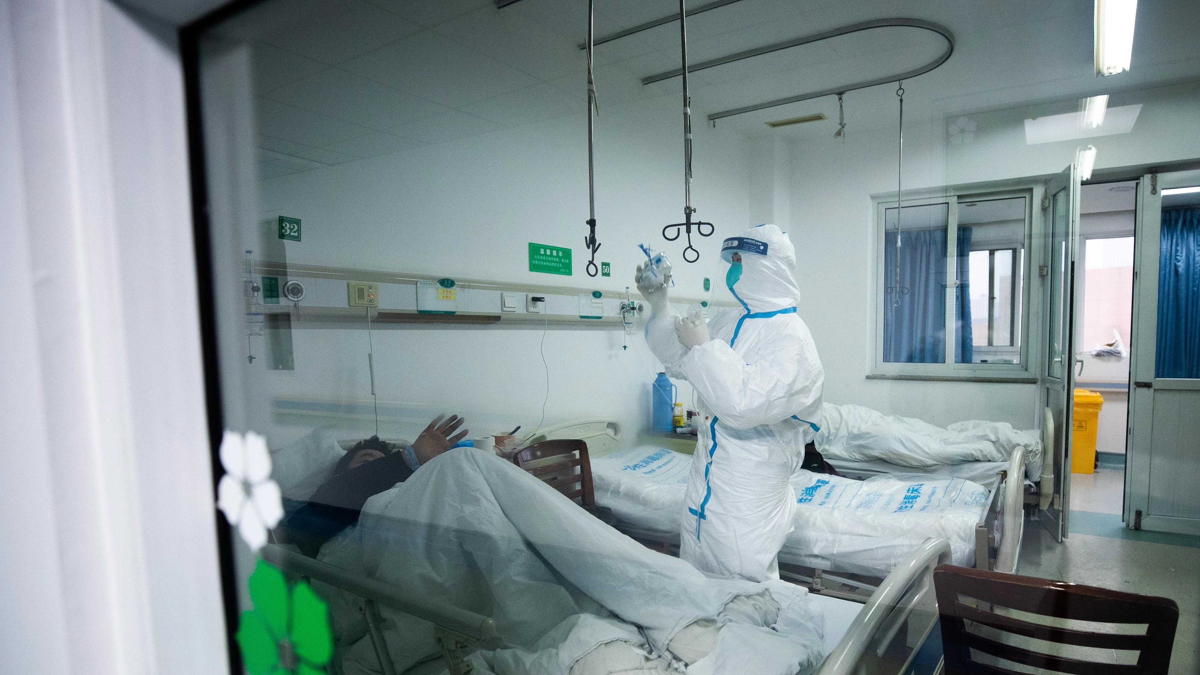 Un sanitario atendiendo a un paciente en un hospital de Wuhan, China