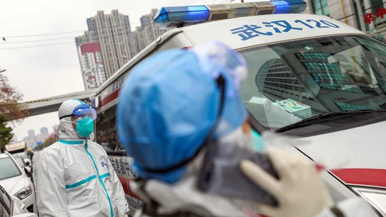 Dos sanitarios junto a una ambulancia en China Dos sanitarios junto a una ambulancia en China