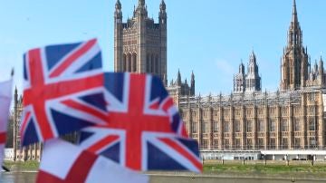 Banderas del Reino Unido ondean frente a las Casas del Parlamento en Londres
