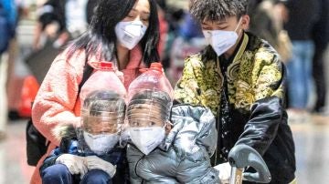 Imagen de unos dos niños con protecciones faciales improvisadas a partir de botellas de plástico para protegerse del coronavirus