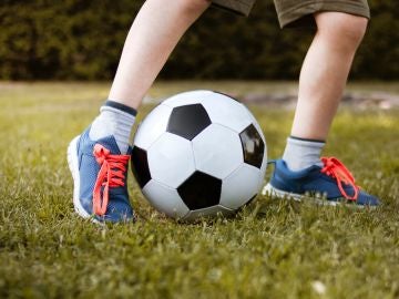 Un niño jugando al fútbol Un niño jugando al fútbol
