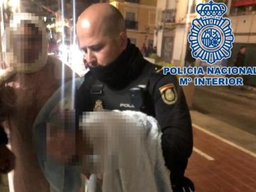 Uno de los policías sosteniendo al bebé en brazos Uno de los policías sosteniendo al bebé en brazos