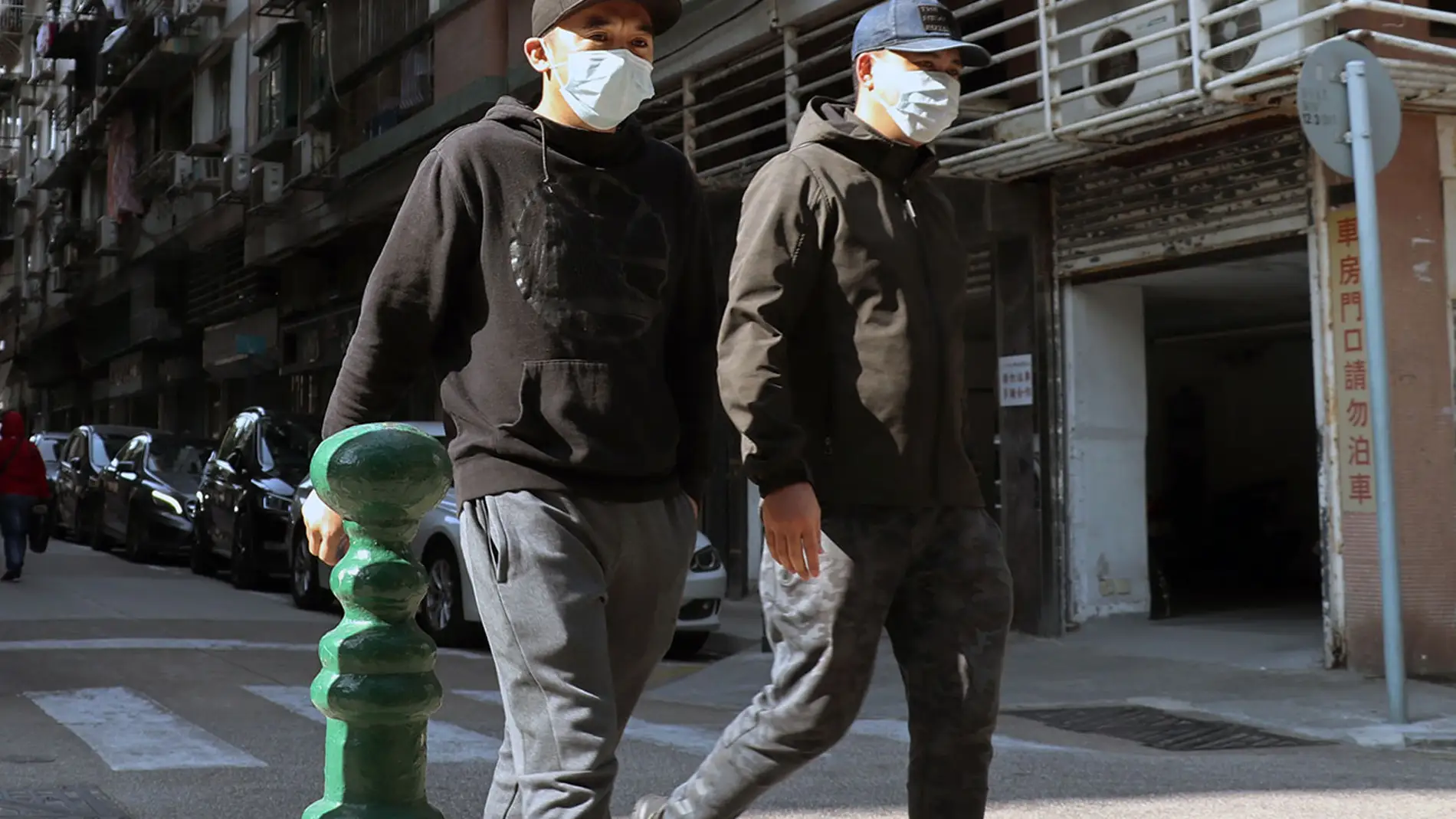 Dos personas pasean con mascarillas en Macao