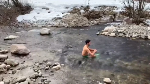 Novak Djokovic en un río helado en una montaña nevada