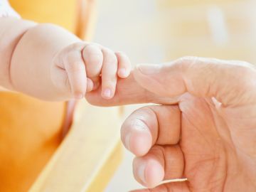 Imagen de archivo de un bebé cogiendo la mano de un adulto. Imagen de archivo de un bebé cogiendo la mano de un adulto.