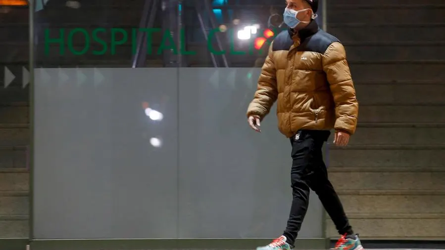 Un hombre porta una mascarilla sanitaria a su paso por la entrada principal del Hospital Clínic