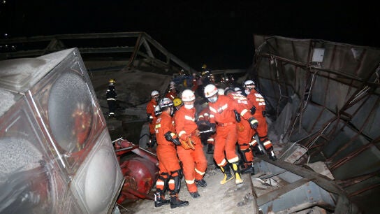 Operarios sacan el cuerpo de uno de los atrapados en el colapso del hotel de Quanzhou