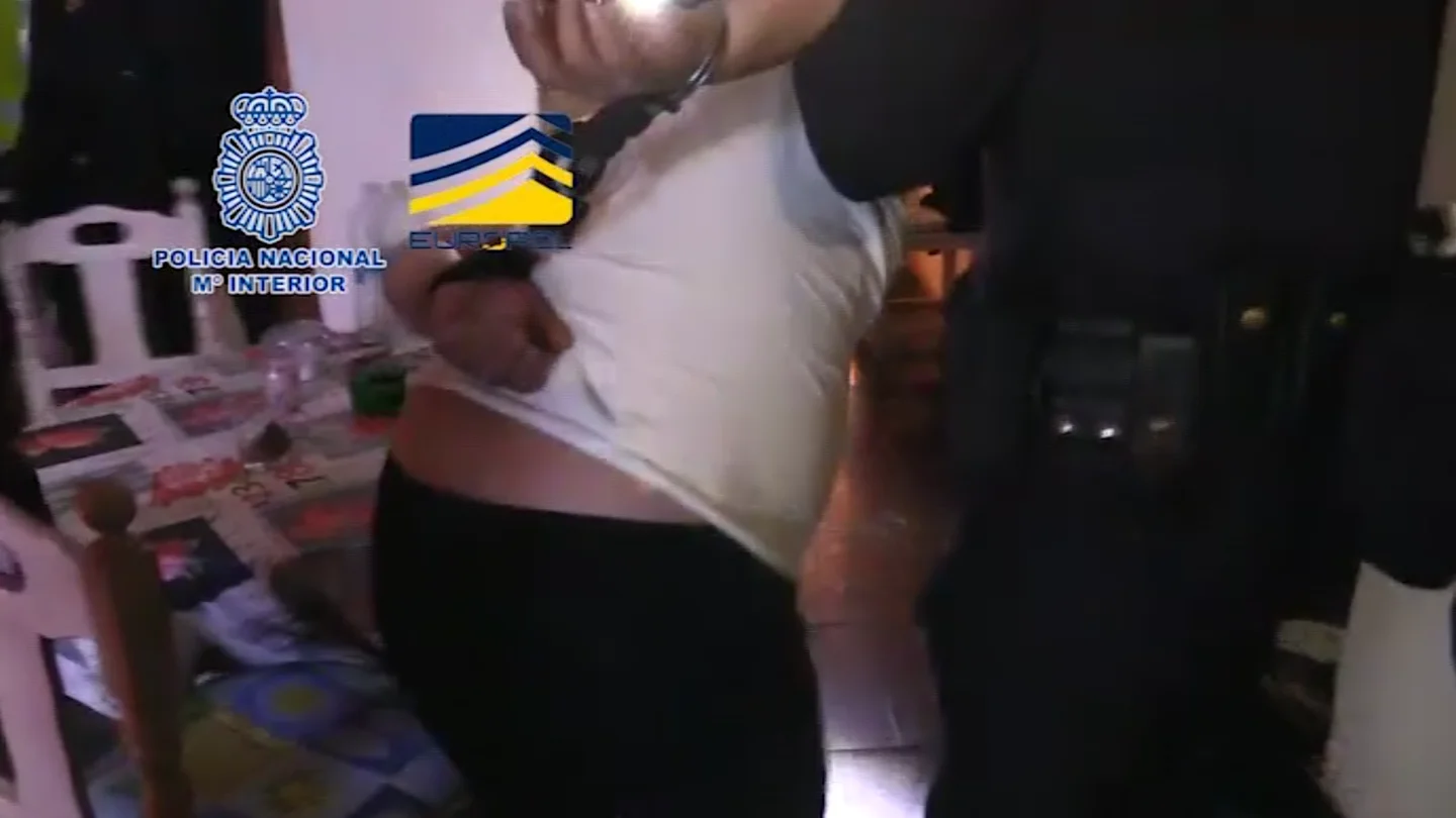 Un agente se lleva esposado a uno de los detenidos de una organización que explotaba a mujeres rumanas Un agente se lleva esposado a uno de los detenidos de una organización que explotaba a mujeres rumanas
