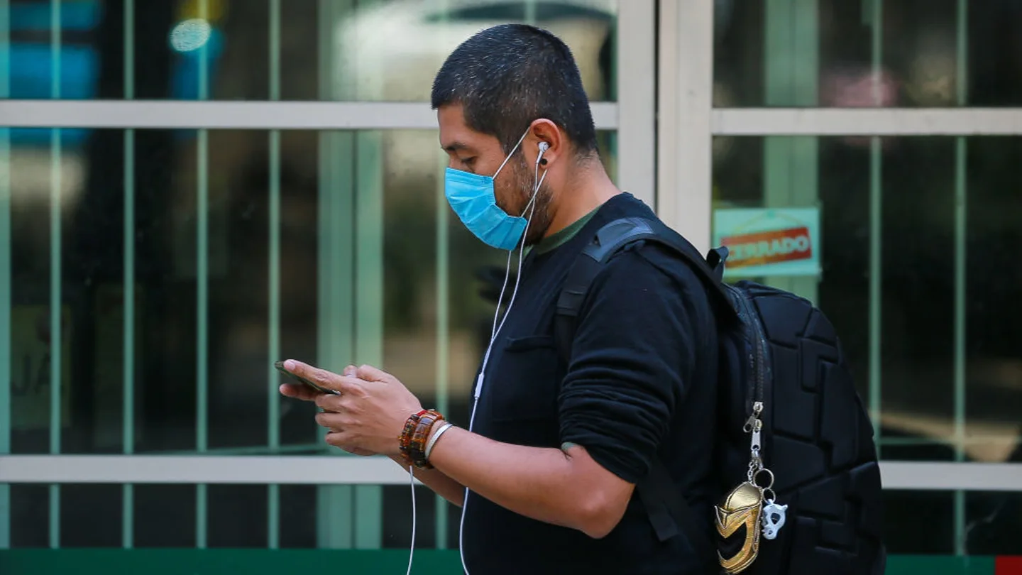 Coronavirus | Un hombre con mascarilla consulta su teléfono Coronavirus | Un hombre con mascarilla consulta su teléfono