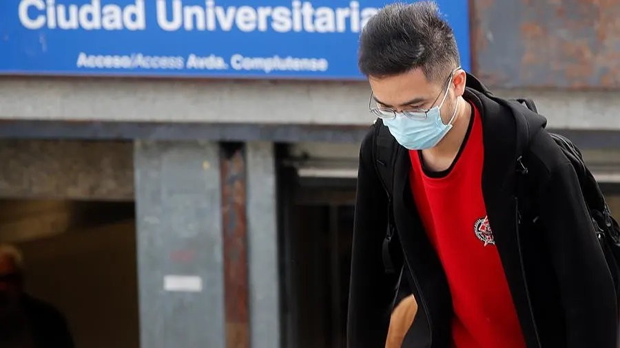 Un joven con mascarilla en el acceso a la estación de metro de Ciudad Universitaria, en Madrid