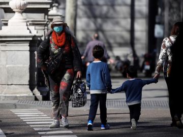 Un par de niños cruzan una calle en Madrid Un par de niños cruzan una calle en Madrid