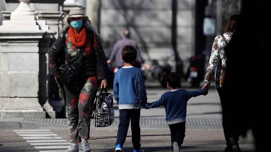 Un par de niños cruzan una calle en Madrid Un par de niños cruzan una calle en Madrid