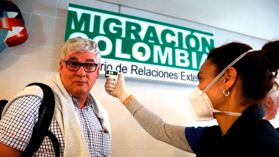 Funcionarios toman la temperatura de los ciudadanos que llegan al aeropuerto internacional El Dorado Funcionarios toman la temperatura de los ciudadanos que llegan al aeropuerto internacional El Dorado