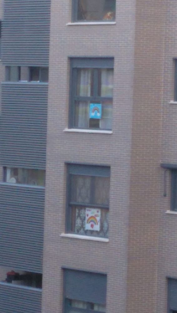 Pancartas con arcoiris en las ventanas con mensajes de ánimo para combatir el confinamiento