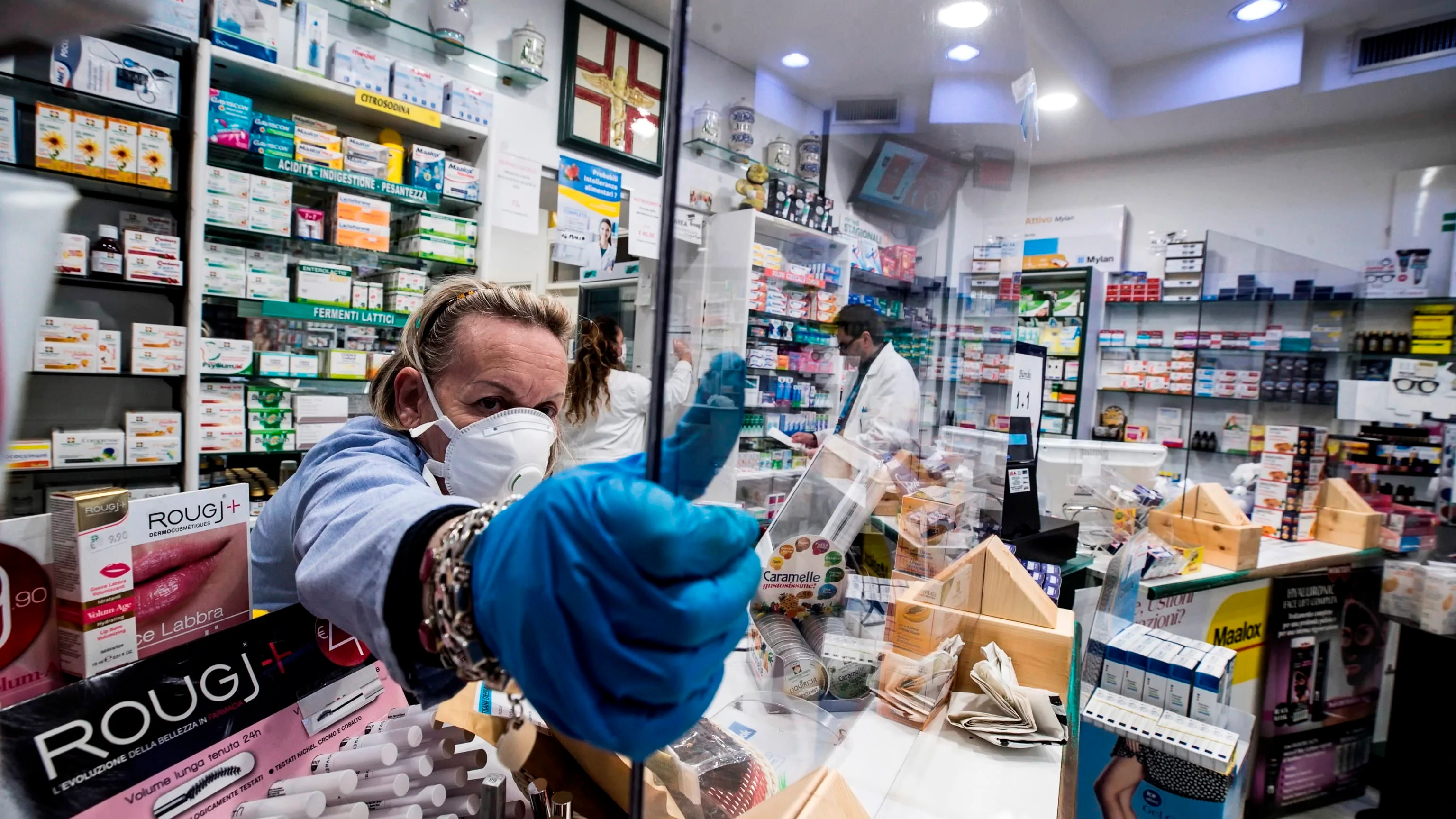 Una farmacia protege con plexiglás al personal durante el cierre de emergencia debido al brote de coronavirus en Roma