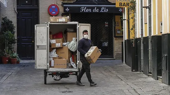 Un repartidor con guantes y mascarilla en Sevilla Un repartidor con guantes y mascarilla en Sevilla