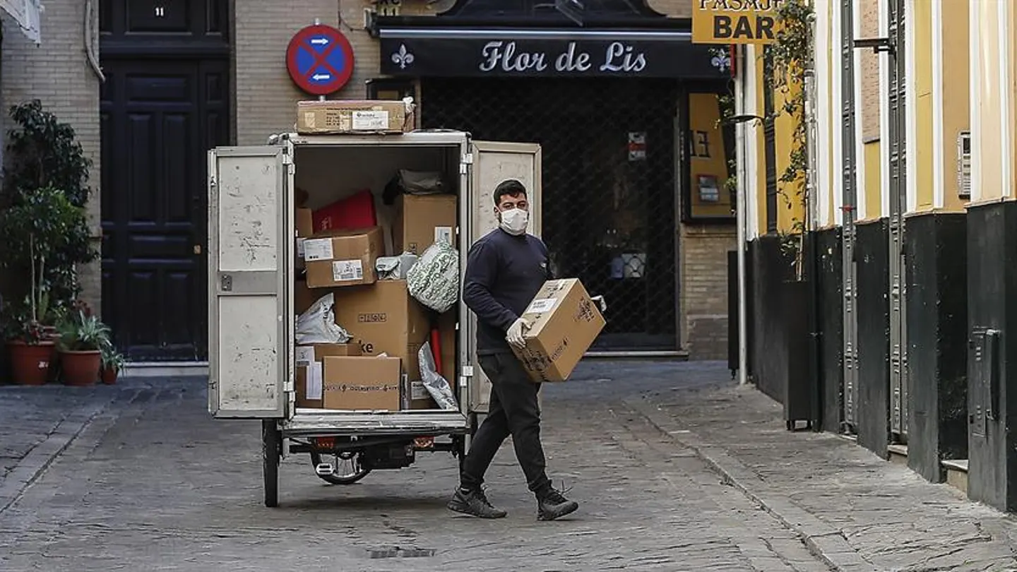 Un repartidor con guantes y mascarilla en Sevilla Un repartidor con guantes y mascarilla en Sevilla