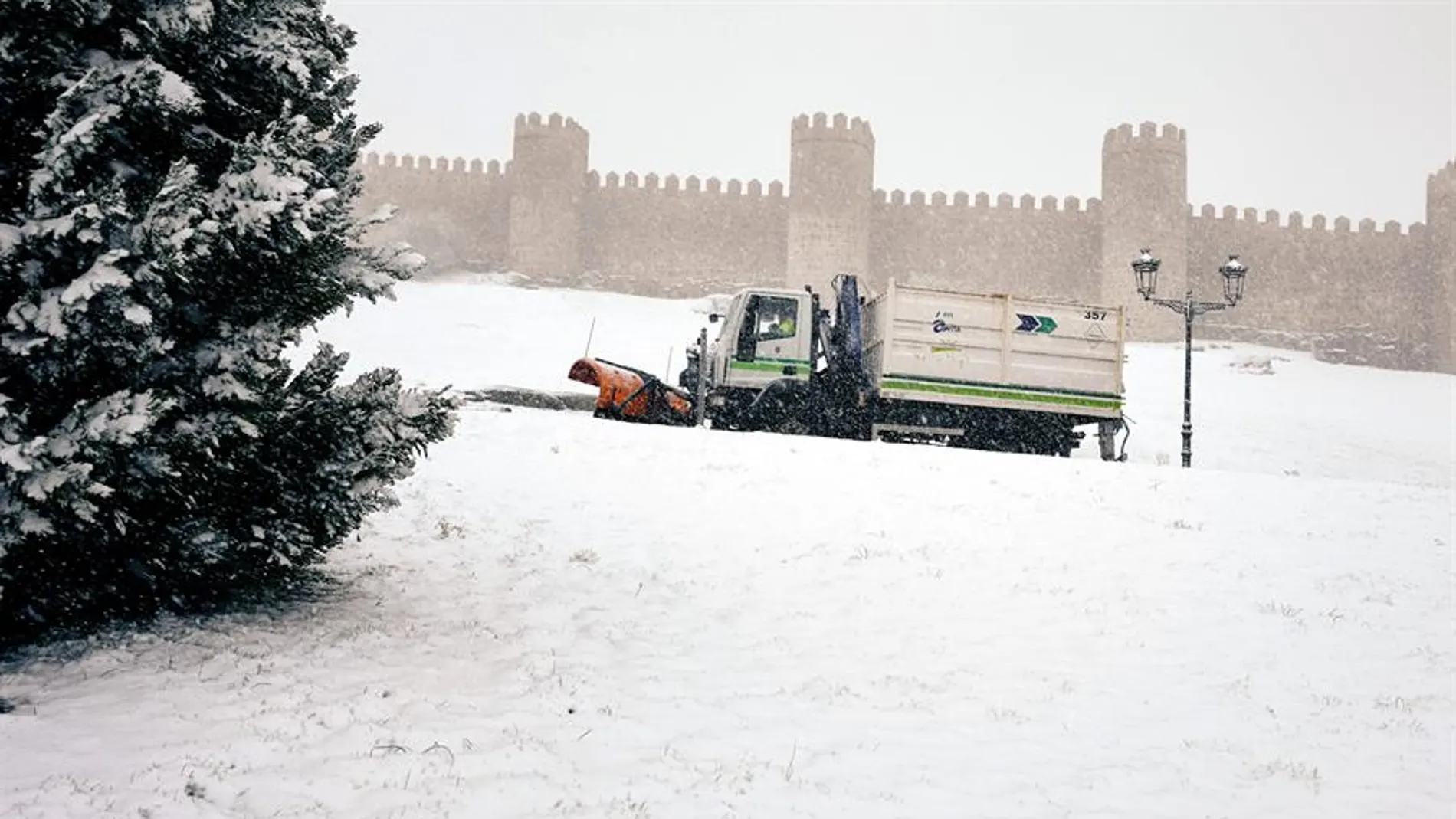 Una máquina quitanieves retira la nieve junto a la muralla de Ávila