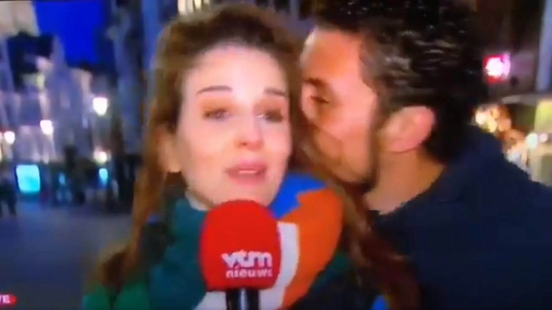 Un hombre besa a una reportera
