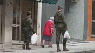 El momento en el que dos soldados llevan la compra a una anciana en Gijón
