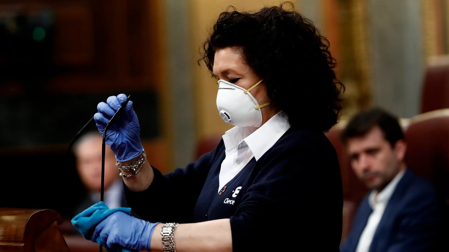Valentina, que trabaja como ujier en el Congreso, desinfecta el atril Valentina, que trabaja como ujier en el Congreso, desinfecta el atril