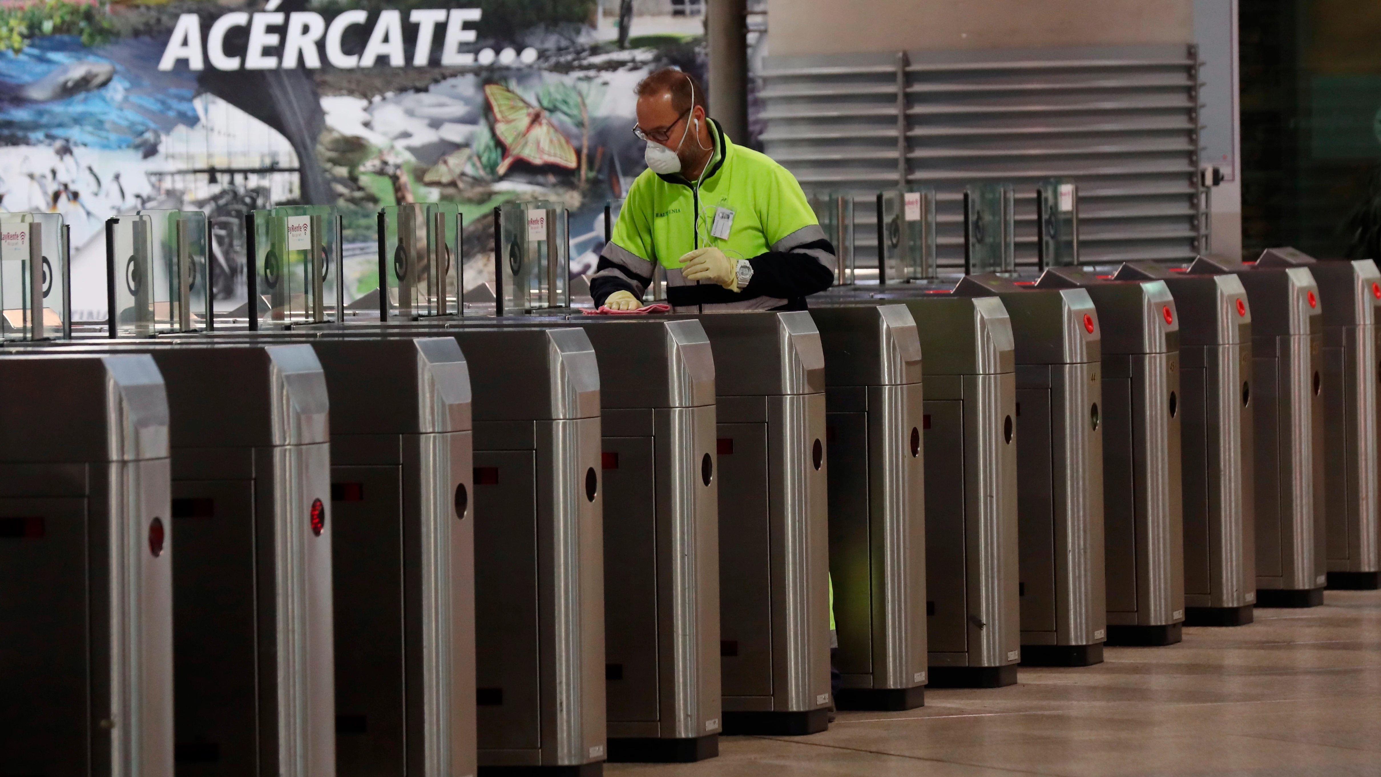 Un operario desinfecta los tornos del Cercanías en la estación de Atocha en Madrid