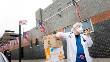 Un sanitario habla por teléfono en Nueva York con la mascarilla puesta